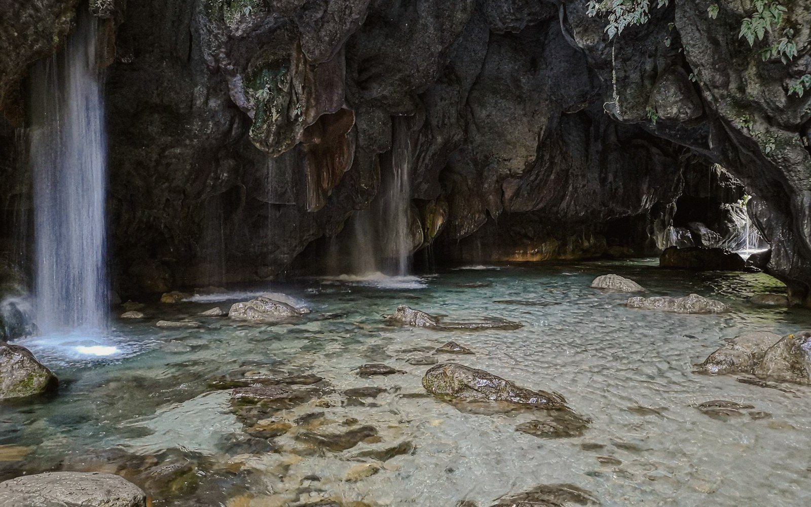 A karst spring emerging at the foot of a cliff
